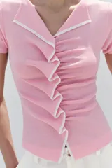 Top de punto color rosado, con cuello en V, manga corta y detalle de frunces delanteros con ribetes a contraste.
