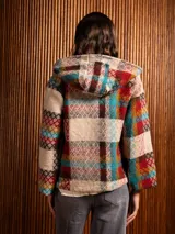 Abrigo de lana con capucha, estampado a cuadros multicolor, cierre frontal con botones y bolsillos delanteros.