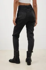 Pantalón de jean negro con corte skinny y tachas plateadas.