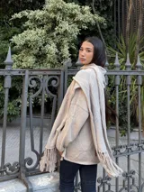 Bufanda tejida en color marrón con diseño de rombos en relieve y terminación con flecos en los extremos. Incluye una etiqueta de cuero sintético con la marca Diversa.