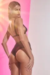Conjunto de bikini negro confeccionado en lycra brillante. El corpiño es de estilo triángulo con breteles anchos fijos y pinzas para dar volumen. La bombacha es de tiro medio.