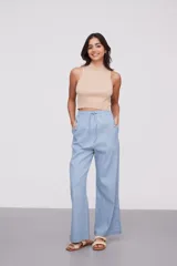 Pantalón celeste de algodón, de tiro alto y corte ancho, con cintura elástica ajustable mediante cordón y aberturas laterales en los bajos.