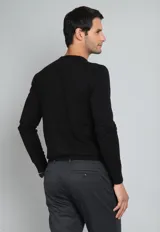 Sweater de algodón color verde petróleo, con cuello redondo y mangas largas.