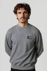 Buzo gris oscuro con cuello redondo y parche con la bandera de Estados Unidos en el pecho.