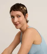 Kit de cuatro pinzas para el pelo en color dorado, con diseños de caracolas y estrella de mar. Algunas piezas presentan incrustaciones de cristales brillantes.