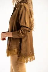 Camisa de satén color arena, de corte clásico con cuello camisero, manga larga con puños abotonados y detalle de encaje en el ruedo.