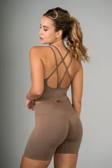 Top deportivo color marrón con breteles finos cruzados en la espalda y diseño acanalado.