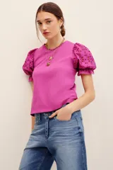 Remera fucsia con mangas abullonadas de broderie estilo globo, con cuello redondo y diseño liso en el cuerpo.