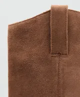 Bota de caña alta estilo cowboy confeccionada en piel de serraje color marrón, con tacón rectangular y punta fina.