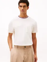 Remera de manga corta confeccionada en tejido de piqué de algodón, con cuello redondo y bolsillo de parche en el pecho. Presenta detalles tricolores en el cuello y un diseño de corte regular.