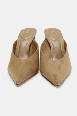 Zapato tipo mule con tacón alto fino y acabado en punta, confeccionado en material con textura gamuzada.