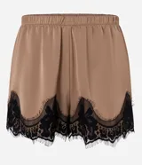 Short de satén color beige con acabado brillante, corte holgado, cintura elástica y detalle de encaje floral negro en el bajo.
