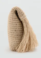 Bolso tipo sobre color tostado, elaborado en tejido de fibra natural con panel de flecos en la parte frontal. Cuenta con forro interior y diseño sin cierre.