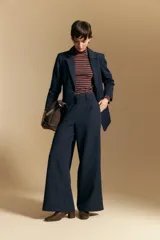 Pantalón de vestir negro de corte ancho y tiro alto, con silueta fluida y diseño minimalista.