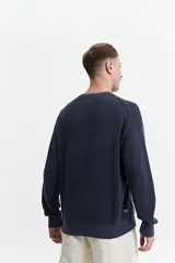 Buzo de punto oversize color negro, con escote redondo y puños.