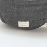 Riñonera gris de tela con cierre color crema y correa de algodón color crudo.