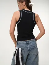 Musculosa de tela rib color marfil, con escote nadador, corte ajustado al cuerpo y costuras a contratono en color marrón.