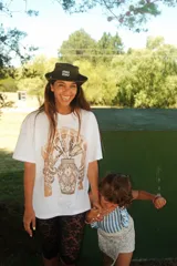 Remera oversize color marrón claro con estampado frontal de un paisaje desértico con palmeras y un camello.