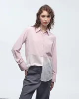 Camisa bicolor rosa y blanco, confeccionada en seda y poliéster. Tiene cuello camisero, cartera con botones, bolsillo plaqué, mangas largas con pliegues en los puños y tablitas en la espalda.