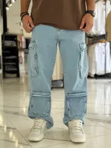 Pantalón cargo de jean azul claro, de corte ancho y relajado, con múltiples bolsillos utilitarios en los laterales y muslos.