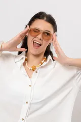 Camisa de lino blanca con silueta amplia y larga, con abertura vertical en la espalda y tiras para atar.