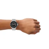 Reloj analógico de estilo deportivo con caja de acero inoxidable de 42 mm y malla de eslabones plateada. Presenta una esfera negra con acabado sunray, índices luminiscentes y movimiento solar. Incluye bisel giratorio unidireccional y resistencia al agua de 10 ATM.
