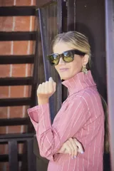 Polerón de cuello alto color rosa viejo con rayas verticales blancas.