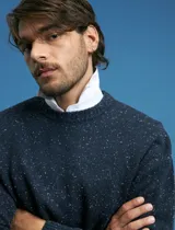 Sweater de punto con cuello redondo y mangas largas, confeccionado en tejido moteado de textura jaspeada.