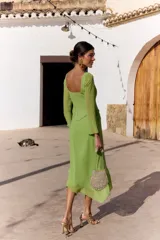 Vestido midi verde claro con efecto dos piezas, compuesto por un corset con escote cuadrado y costuras frontales estructuradas, y falda midi fluida de corte asimétrico. Cuenta con mangas largas semitransparentes.