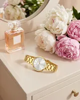 Reloj analógico para mujer con caja y malla de acero inoxidable en color dorado. Presenta una esfera minimalista con fondo blanco y marcadores de hora lineales.
