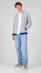 Campera con capucha y cierre frontal, confeccionada en tejido texturizado gris jaspeado. Presenta puños y ruedo en contraste color azul marino, y un pequeño logo bordado en color rojo en el pecho.