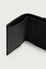 Billetera de acabado engomado en color negro. Cuenta con compartimento principal para billetes, seis ranuras internas para tarjetas, dos ranuras externas y un monedero lateral con cierre de cremallera.
