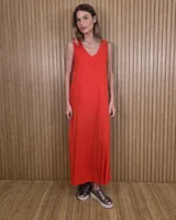 Vestido largo negro de corte holgado, sin mangas y con escote redondo. Presenta detalles de ribetes contrastantes en color beige en los laterales y sisas.
