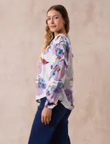 Blusa de gasa estampada con flores, marca Zac & Rachel. Tiene cuello a la base con abertura central con botones y mangas largas abullonadas.