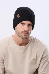 Gorro tejido de punto acanalado con vuelta y etiqueta decorativa de cuero sintético en el lateral.