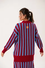 Saco oversize tejido con diseño de rayas verticales en colores rojo y azul. Presenta escote en V, cierre frontal con botones y puños y ruedo acanalados.