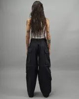 Pantalón cargo negro de gabardina, corte amplio, con múltiples bolsillos y tiras ajustables.