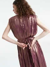 Mono largo sin mangas de corte holgado, confeccionado en tejido plisado con acabado metalizado. Presenta cuello redondo con detalle de abertura y cierre de botón en la parte posterior.