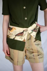 Camisa verde militar de manga corta con botones nacarados y corte estampado en el delantero con diseño de aves.