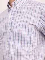 Camisa de manga corta con estampado de cuadros en tonos azul, rojo y beige, confeccionada en algodón. Presenta cuello clásico y cierre frontal con botones.