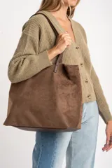 Cardigan de punto acanalado con cuello en V y cierre frontal de botones. Presenta un corte oversize y mangas largas con puños ajustados.