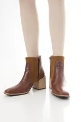 Botas cortas de cuero vacuno en combinación de colores tostado y negro, con diseño bicolor y paneles laterales de gamuza, punta cuadrada y taco bloque ancho.