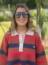 Remerón de algodón a rayas horizontales en tonos rojo, marrón y azul. Tiene cuello tipo polo con botones y mangas cortas.