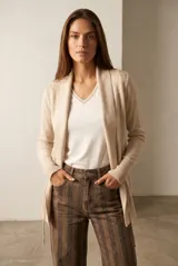 Cardigan abierto de punto color beige con solapa ancha, mangas largas y puños acanalados, con detalles de tejido geométrico en los hombros.