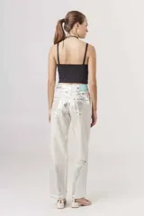 Pantalón de jean corte regular con acabado metalizado plateado, diseño de cinco bolsillos y cierre frontal con botón y cremallera.