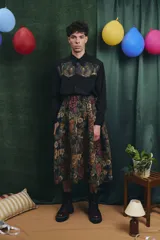 Falda midi de corte amplio con cintura elastizada y frunces laterales, confeccionada en tejido tipo gobelino con estampado floral sobre fondo azul.