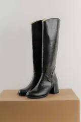 Bota de caña alta color marrón con textura símil reptil, taco cuadrado forrado en cuero y cierre lateral.