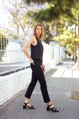 Sandalias negras de cuero con dos tiras, una de cuero liso y otra de charol con estampado animal print. Tienen hebilla metálica plateada y taco bloque.