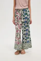 Pantalon de corte relajado y pierna ancha, confeccionado en rayón con estampado floral multicolor. Presenta cintura elástica con cordón ajustable decorado con borlas en los extremos.