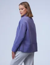 Buzo de jersey color lila con cuello alto y tajos laterales.